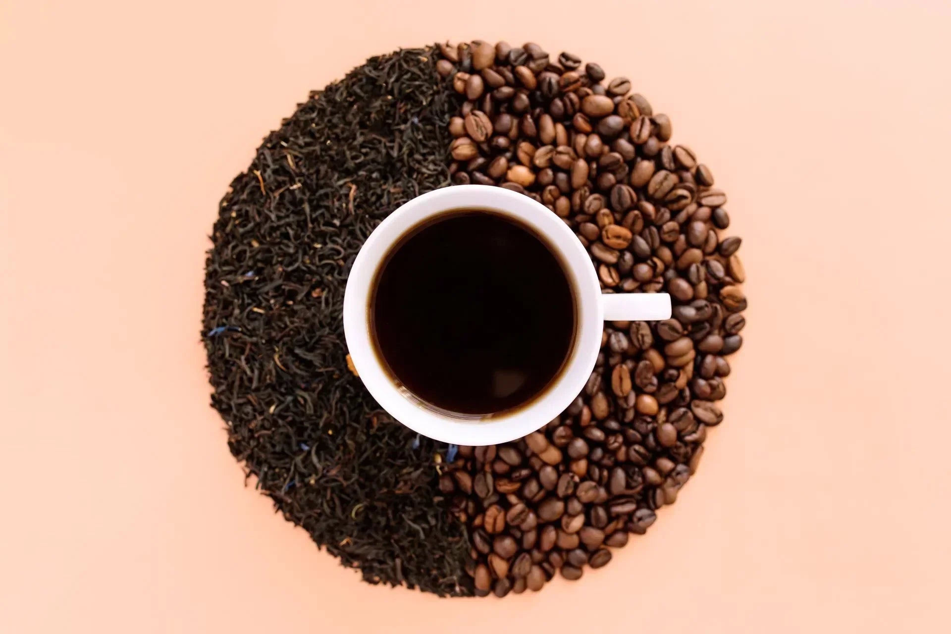 beige flat lay background with white ceramic coffee cup roasted coffee beans and dried tea leaves. 